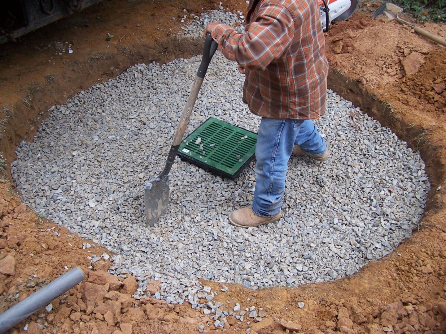 a man filling a drainage hole