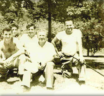 A group of men sitting on top of a dirt hill.