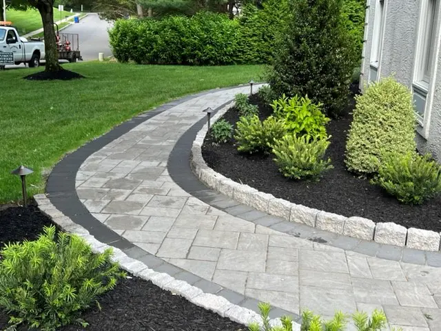Curved paver walkway made of marble in front of house