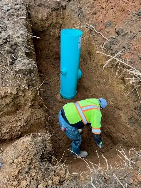 Worker working for water management under a blue big pipe