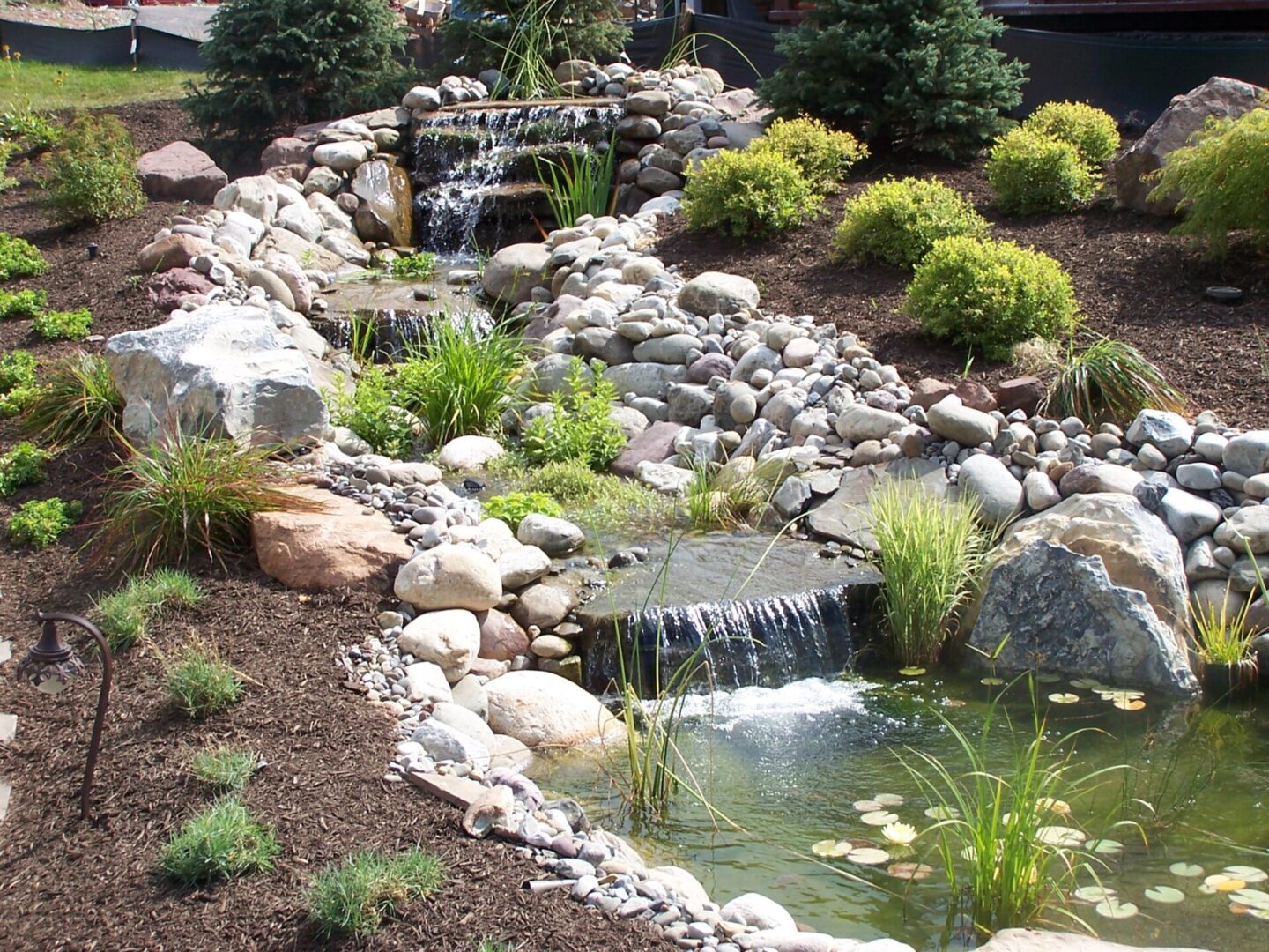 Garden waterfall with rocks and greenery
